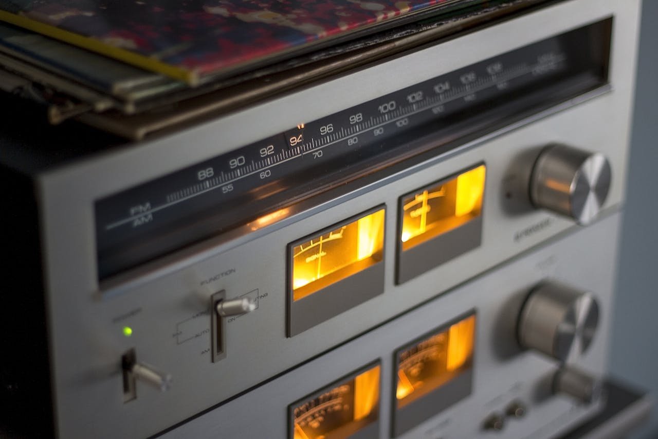 Close-up of retro audio equipment featuring illuminated dials and radio tuner.